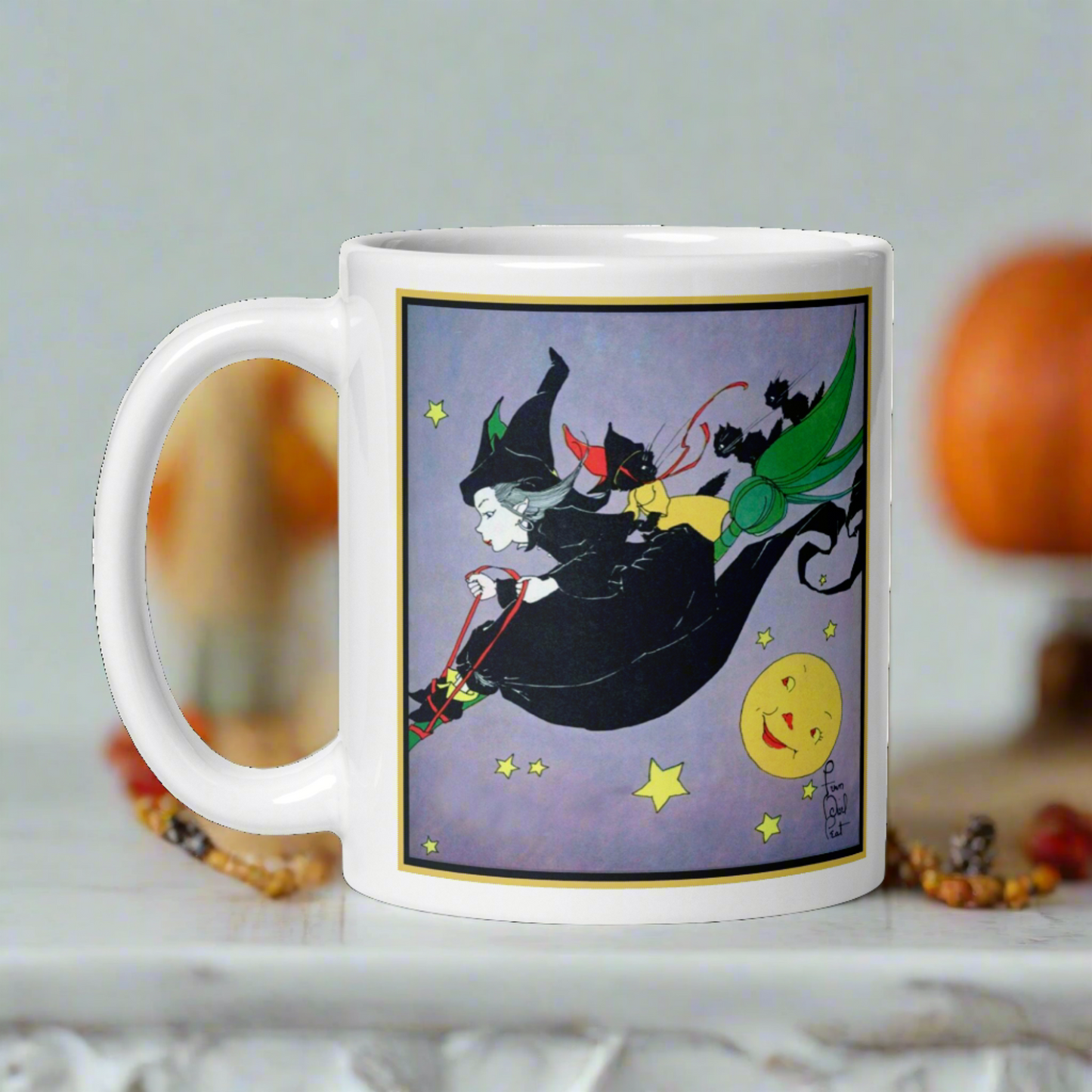 This ceramic glossy mug features a vintage Halloween illustration by Fern Bisel Peat. It features a witch dressed in all black soaring through the air on her broom with black cats. There is a smiling full yellow moon.