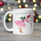 This ceramic glossy coffee mug features a retro vintage Christmas illustration of a woman holding a holly plant checking her mailbox. She is wearing a pink hat, pink and white striped dress, and pink heels. The illustration says A Christmas Note.