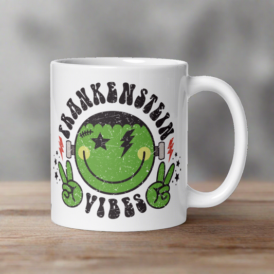 This ceramic glossy mug features a distressed style artwork of an adorable Frankenstein Monster making the peace sign with his hands. Lettering says Frankenstein Vibes around his head with little stars.