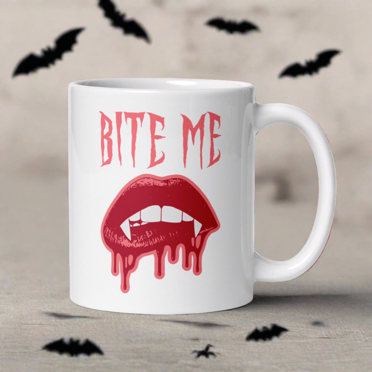 This ceramic coffee mug features the words Bite Me in gothic style with an art design of vampire lips and fangs. 