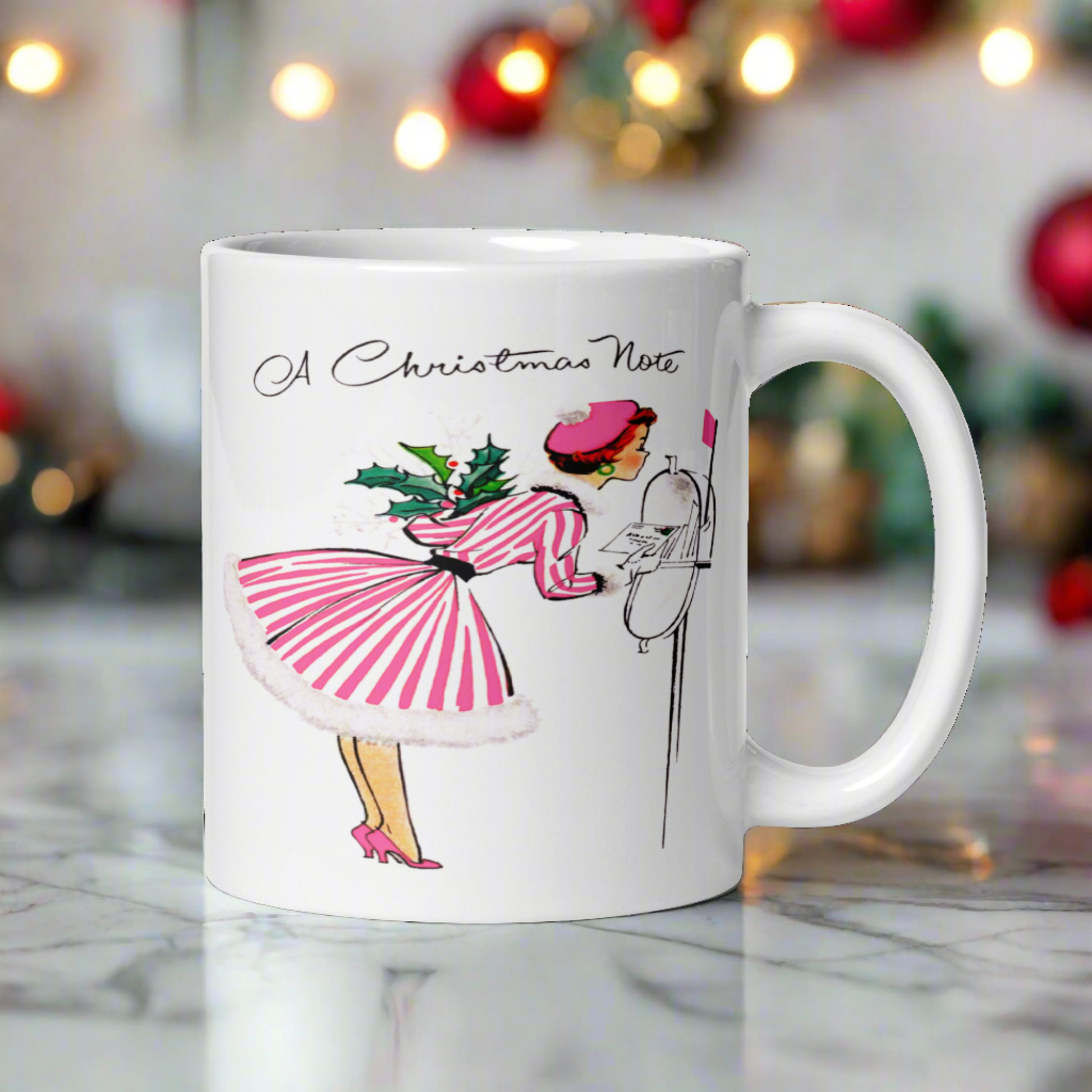 This ceramic glossy coffee mug features a retro vintage Christmas illustration of a woman holding a holly plant checking her mailbox. She is wearing a pink hat, pink and white striped dress, and pink heels. The illustration says A Christmas Note.