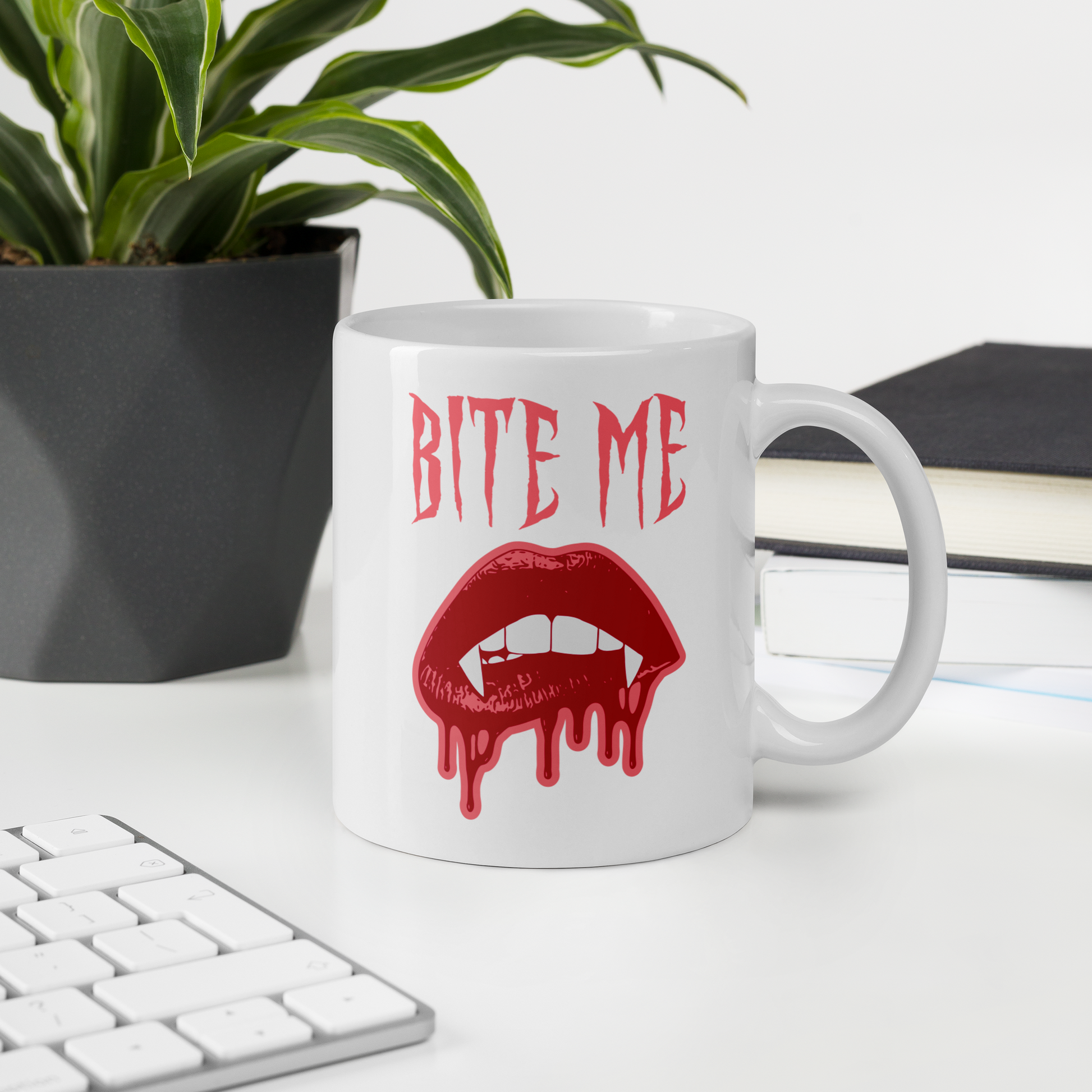 This ceramic coffee mug features the words Bite Me in gothic style with an art design of vampire lips and fangs. 