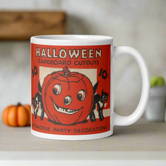 This ceramic glossy coffee mug features a retro illustration of Halloween Decorations. It says Halloween Cardboard Cutouts Attractive Party Decorations. There are two black cats and a jack o lantern.