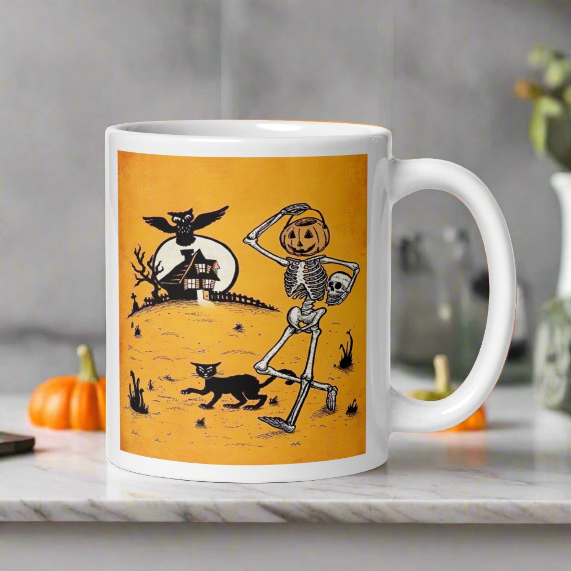 This ceramic glossy coffee mug features a vintage Halloween illustration of a skeleton with a jack o lantern for a head, a black cat, a black owl, a spooky house and a full moon. 