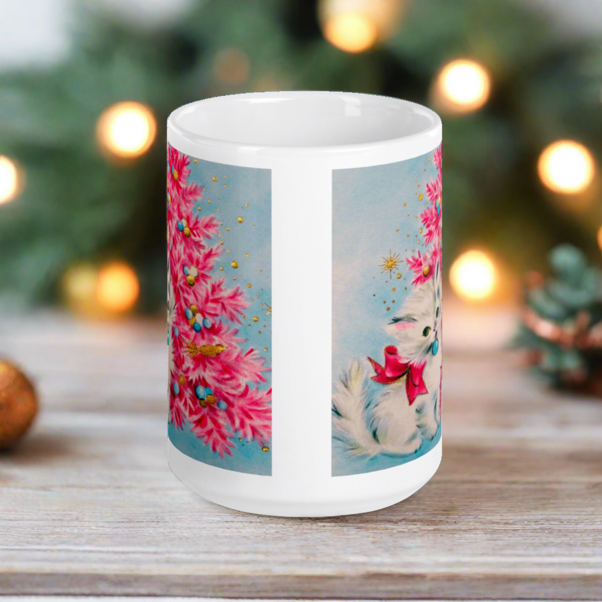 This glossy ceramic coffee cup features an adorable vintage retro print of a white christmas kitten with a blue ornament in her mouth. She is wearing a pink bow and is sitting next to a pink Christmas tree with a blue background.