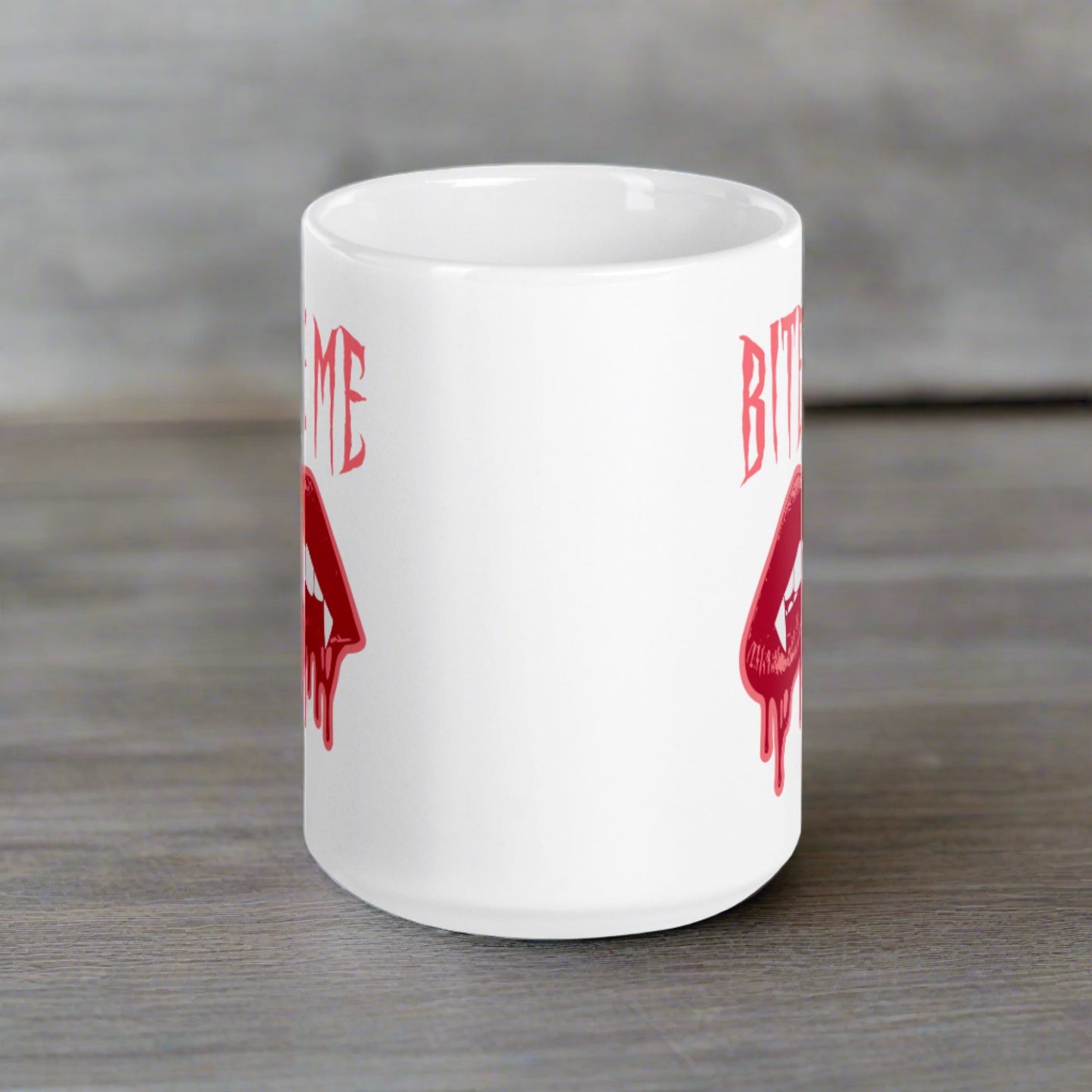 This ceramic coffee mug features the words Bite Me in gothic style with an art design of vampire lips and fangs. 