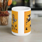 This ceramic glossy coffee mug features a vintage Halloween illustration of a skeleton with a jack o lantern for a head, a black cat, a black owl, a spooky house and a full moon. 