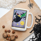 This ceramic glossy mug features a vintage Halloween illustration by Fern Bisel Peat. It features a witch dressed in all black soaring through the air on her broom with black cats. There is a smiling full yellow moon.