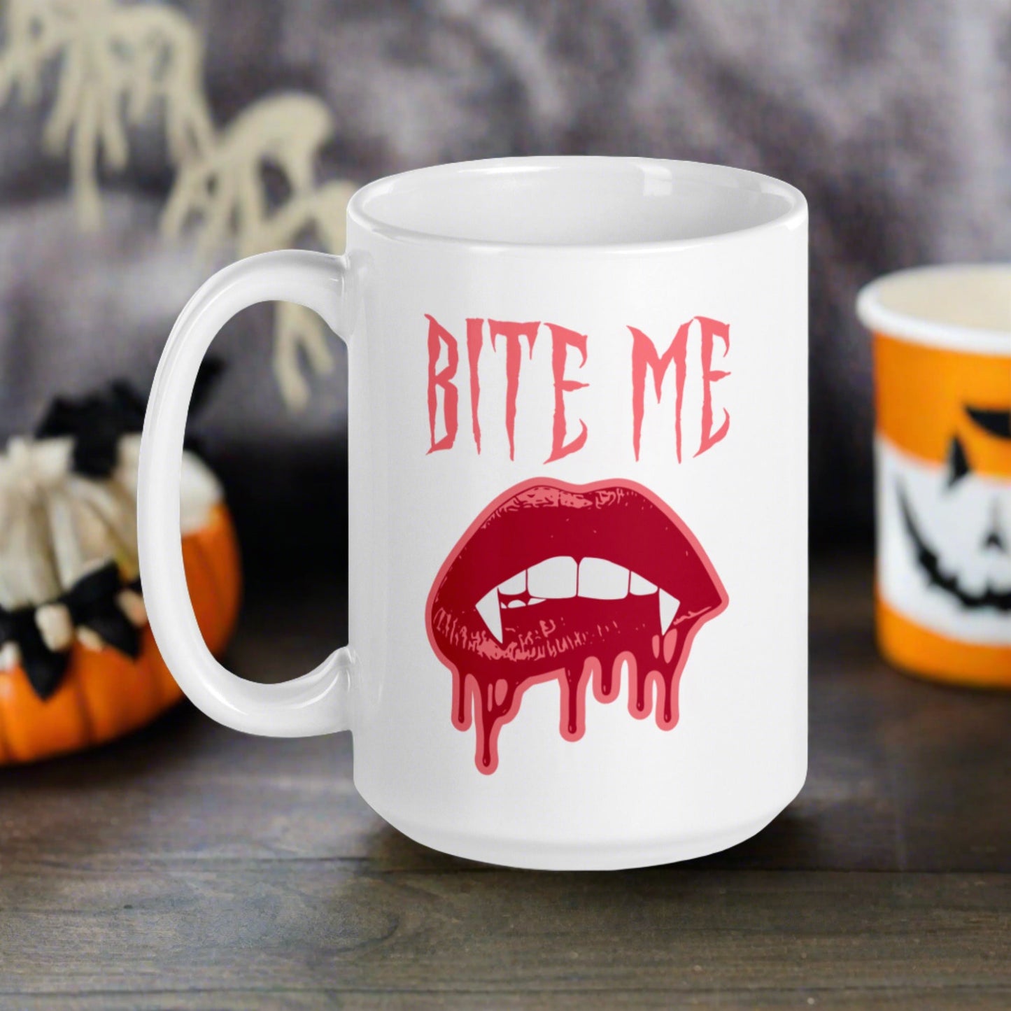 This ceramic coffee mug features the words Bite Me in gothic style with an art design of vampire lips and fangs. 