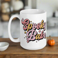 This ceramic glossy coffee mug features cursive lettering that says Spooky Babe. The colors are pastel pinks and yellows and have stars.