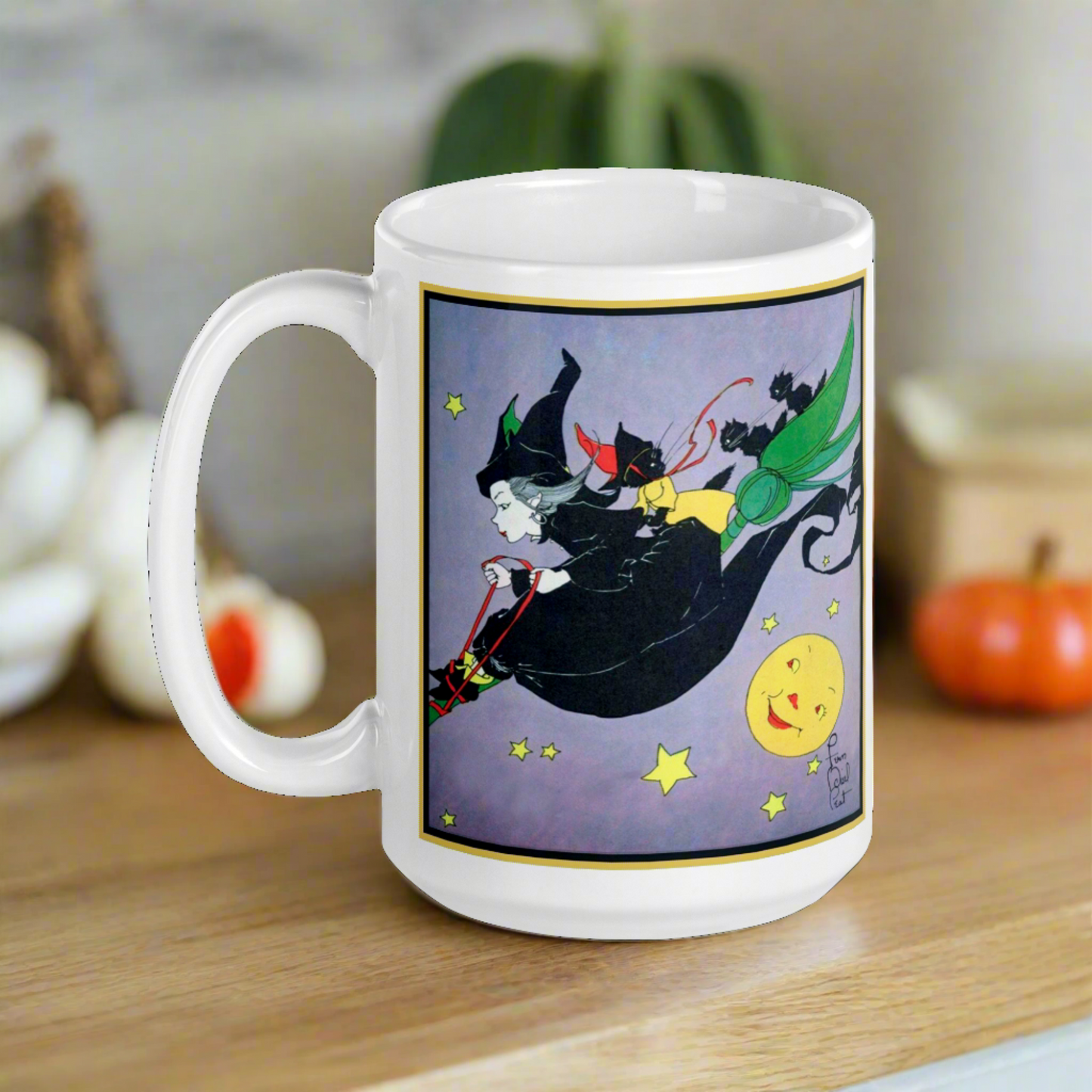 This ceramic glossy mug features a vintage Halloween illustration by Fern Bisel Peat. It features a witch dressed in all black soaring through the air on her broom with black cats. There is a smiling full yellow moon.