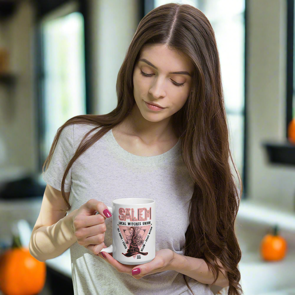 This ceramic glossy mug says Salem Local Witches Union and features a pointy pink and black witch's hat. It says Sky Above Earth Below Peace Within Est 1692.