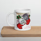 This white ceramic glossy coffee mug features two adorable kittens in red stockings at a Christmas mantle. The print is retro kitsch and says A Pair of Warm Wishes.