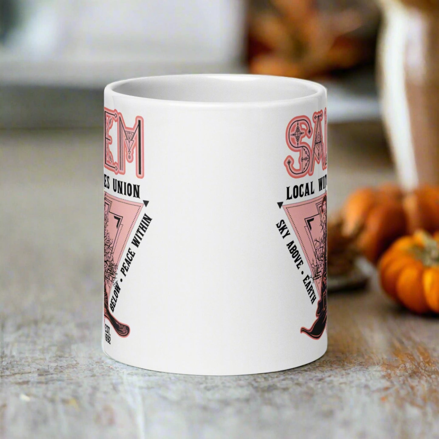 This ceramic glossy mug says Salem Local Witches Union and features a pointy pink and black witch's hat. It says Sky Above Earth Below Peace Within Est 1692.