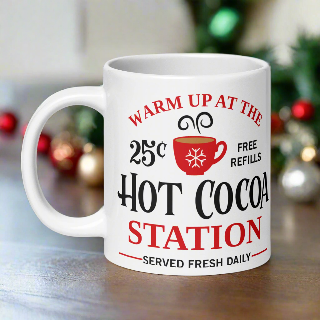 This ceramic glossy coffee mug says Warm Up At The Hot Cocoa Station Served Fresh Daily.It features a cute little red cup with a snowflake on it.