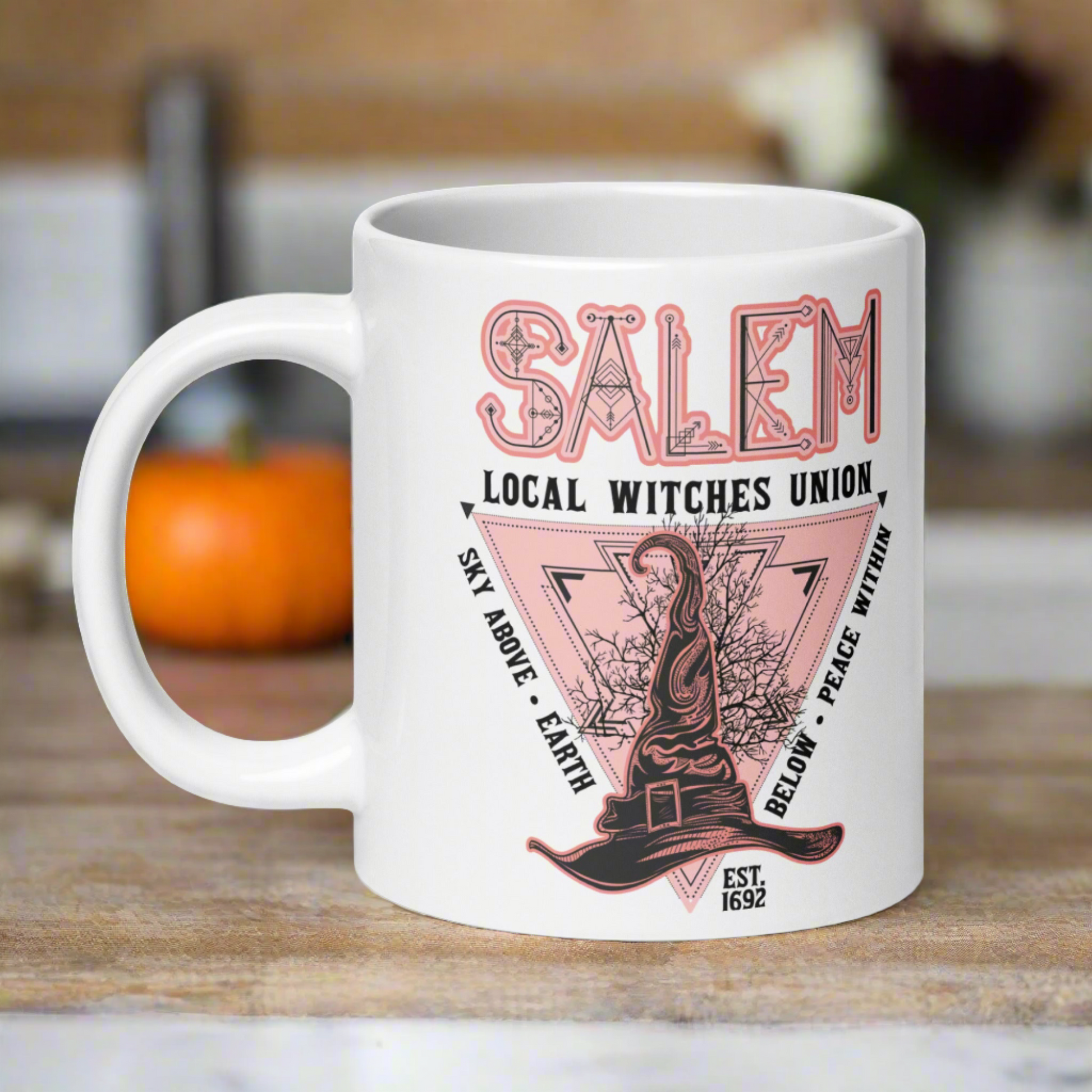 This ceramic glossy mug says Salem Local Witches Union and features a pointy pink and black witch's hat. It says Sky Above Earth Below Peace Within Est 1692.