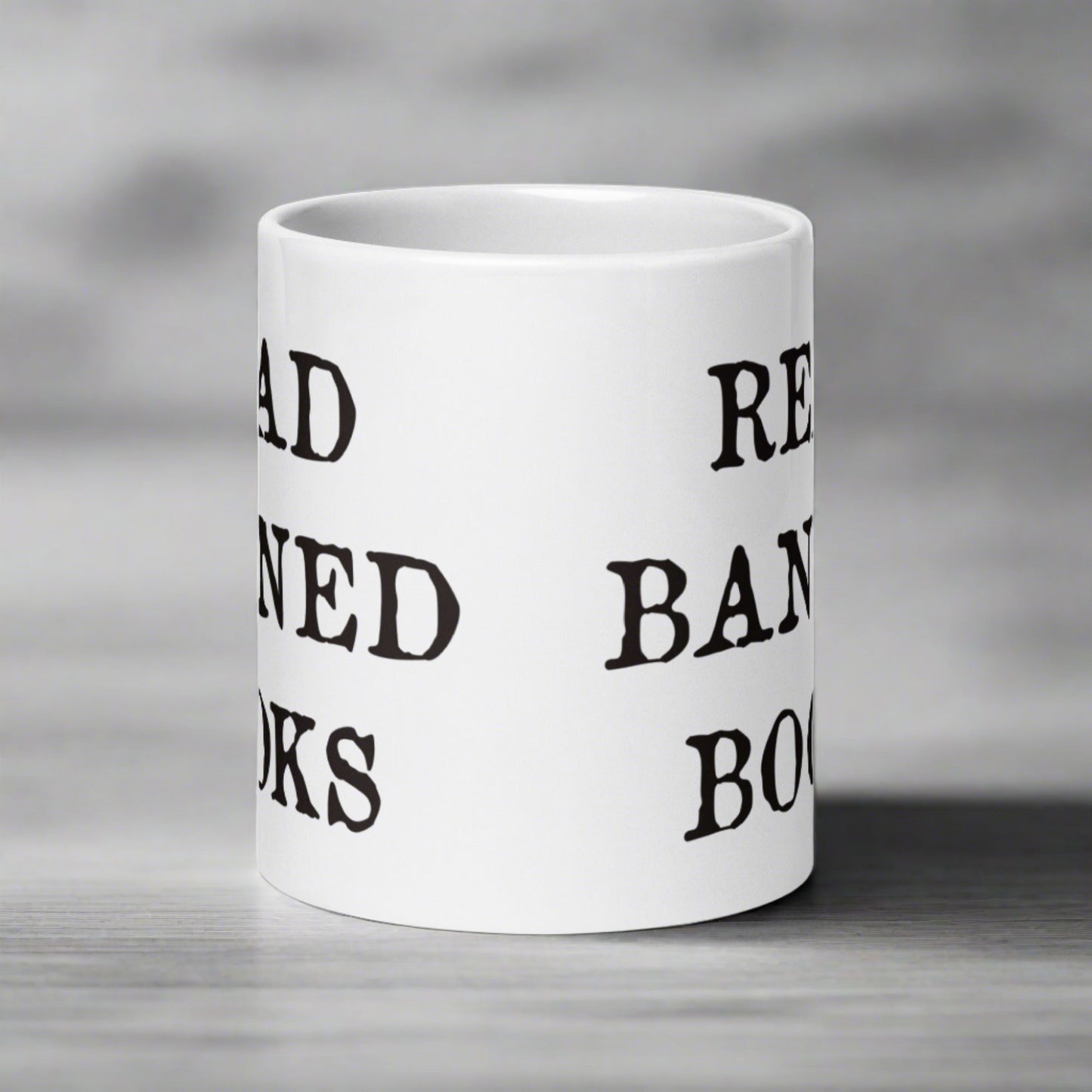 This ceramic glossy white coffee mug features black lettering that says Read Banned Books.