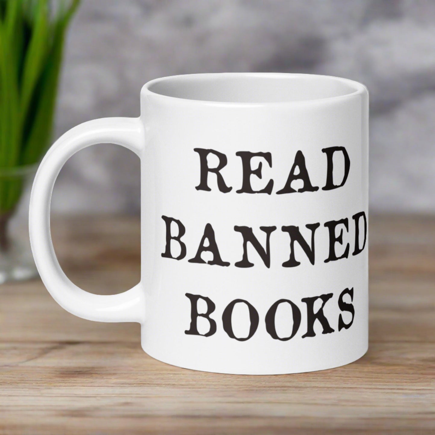 This ceramic glossy white coffee mug features black lettering that says Read Banned Books.