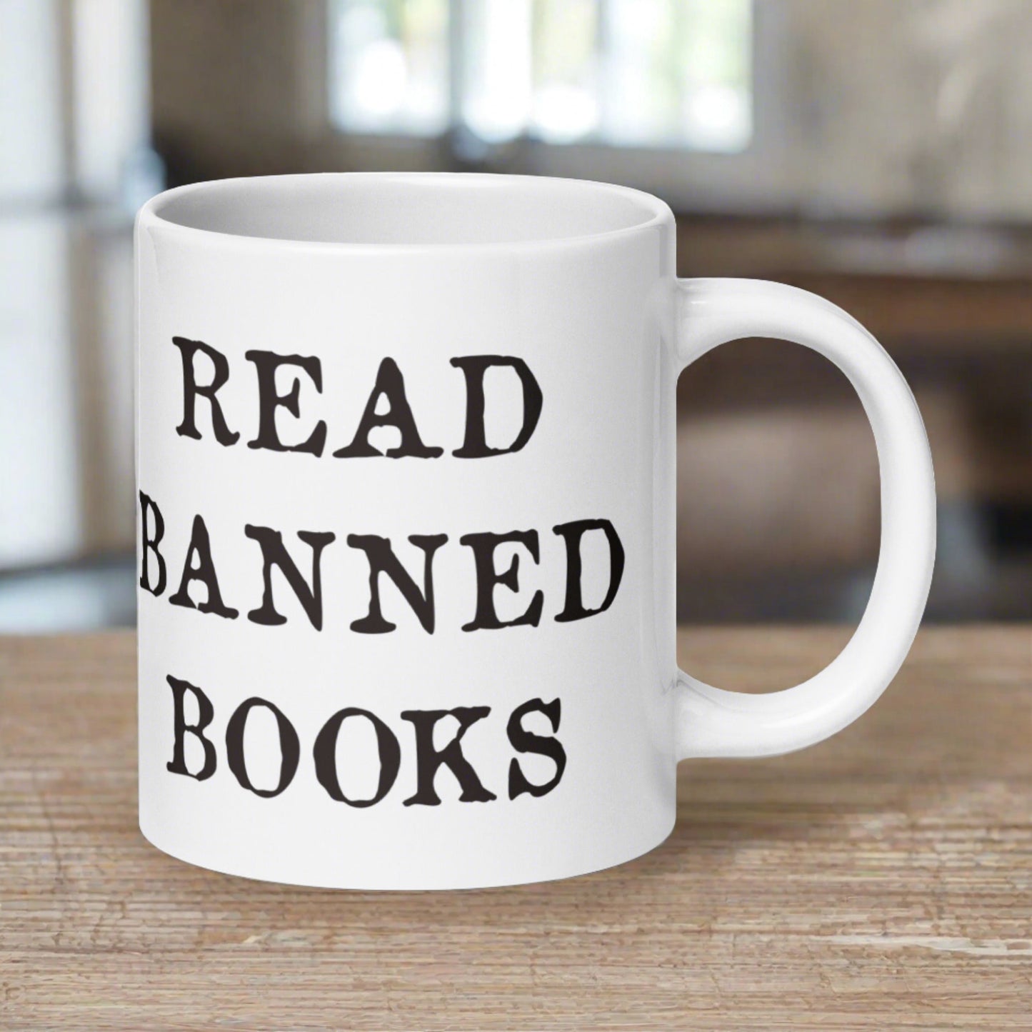 This ceramic glossy white coffee mug features black lettering that says Read Banned Books.